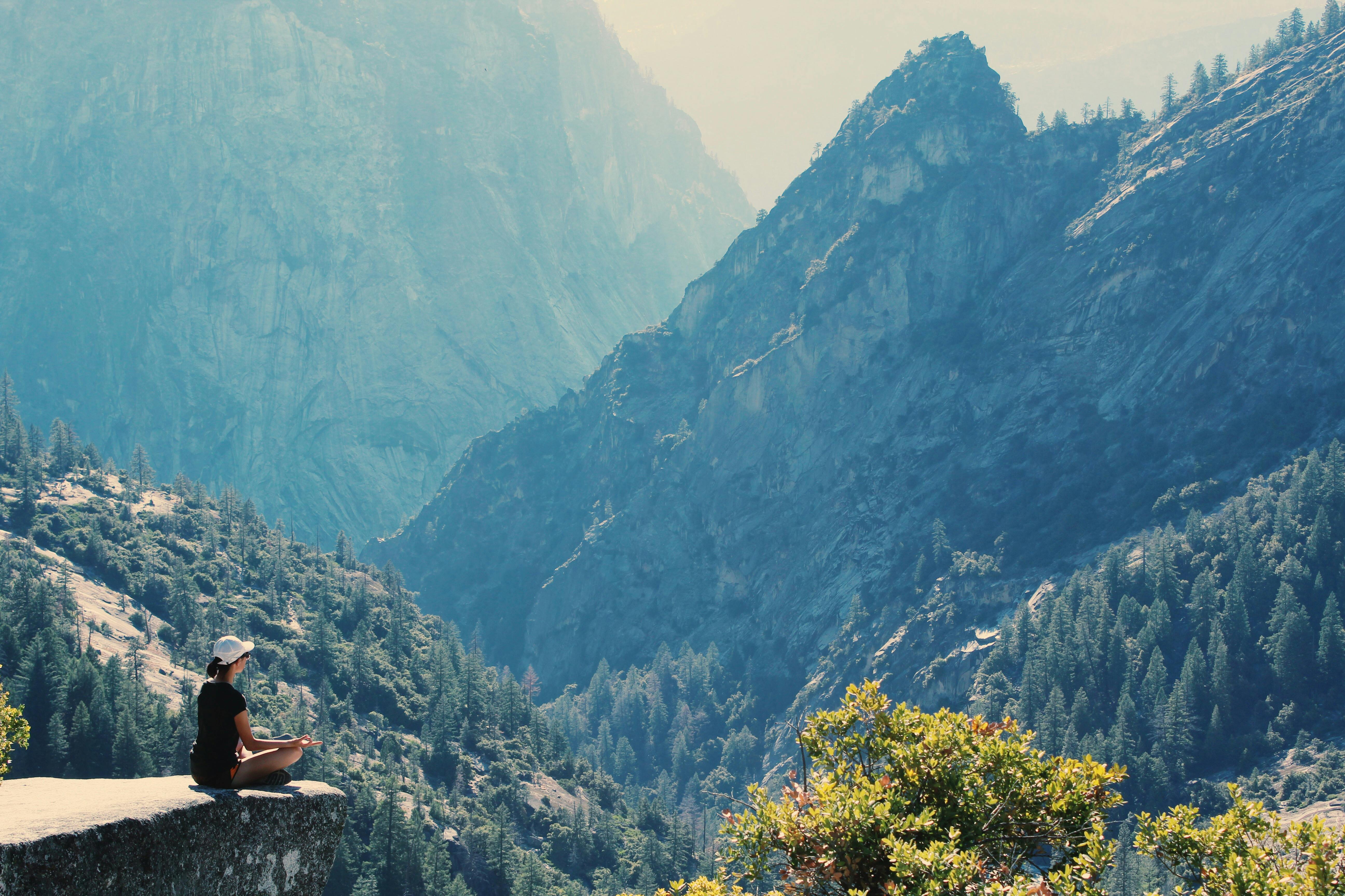 Man standing on mountain peak, symbol of resilience and strength