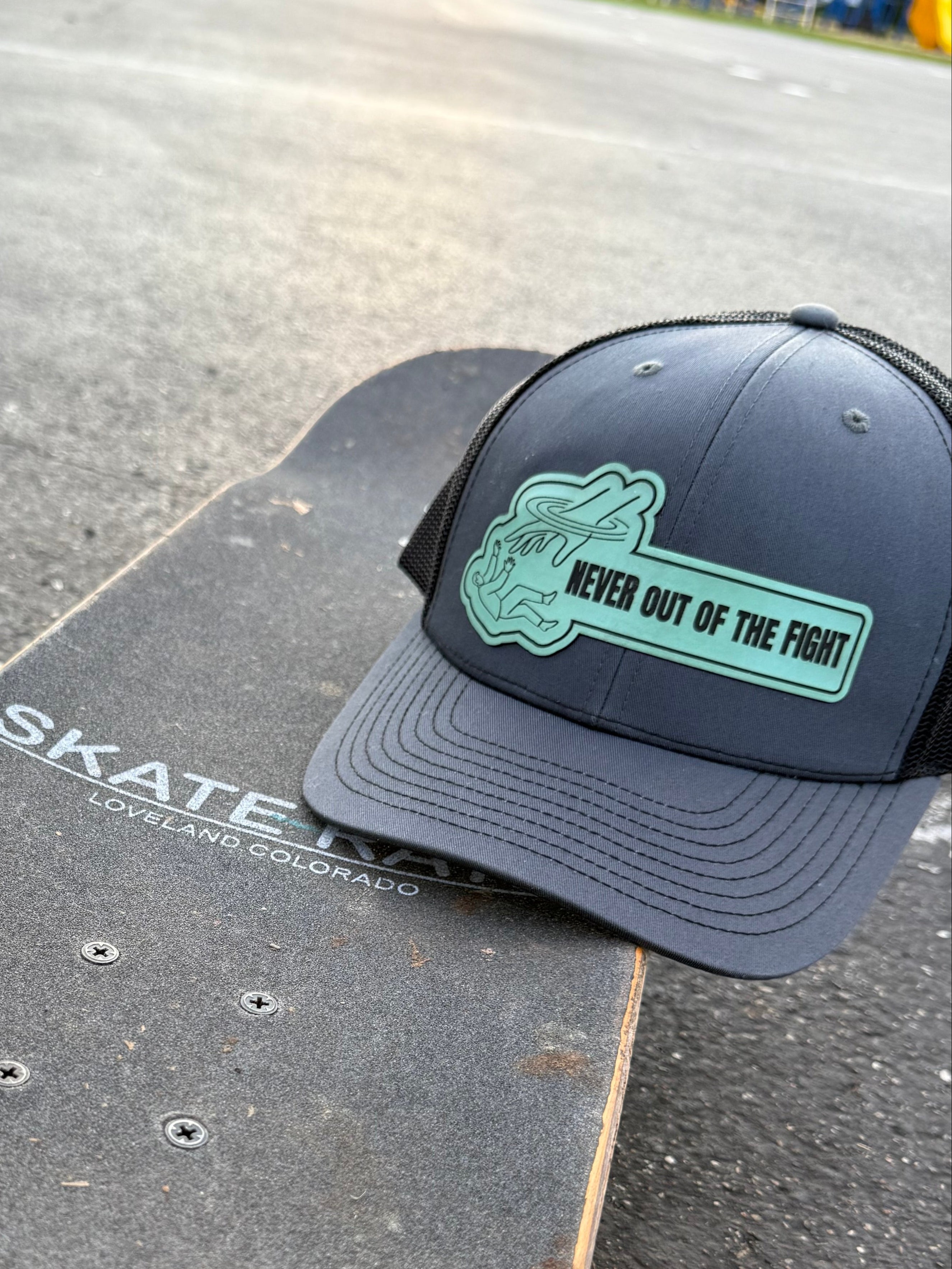 Black cap with green logo on a skateboard
