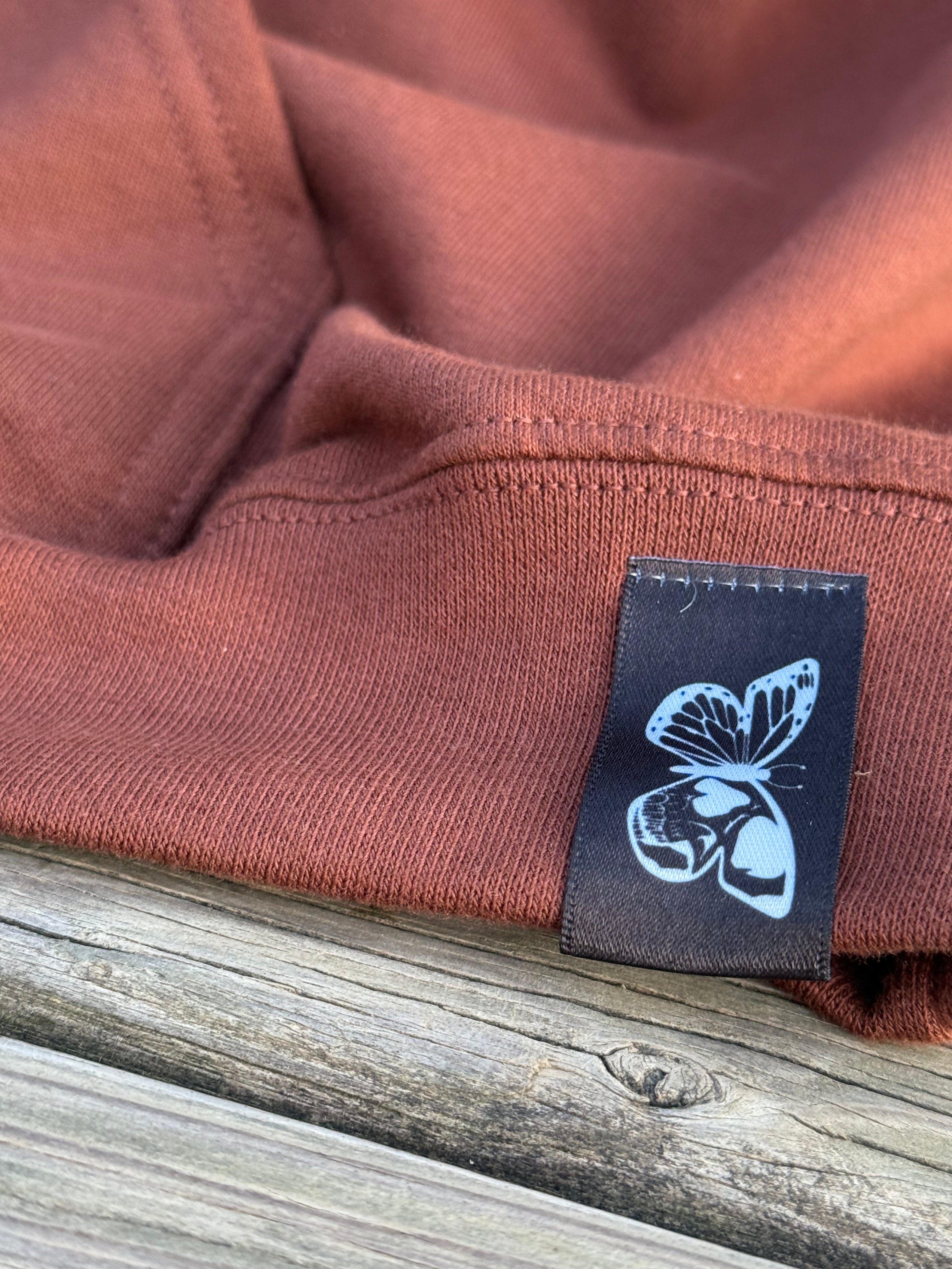 Close-up of Weather the Storm hoodie front patch design