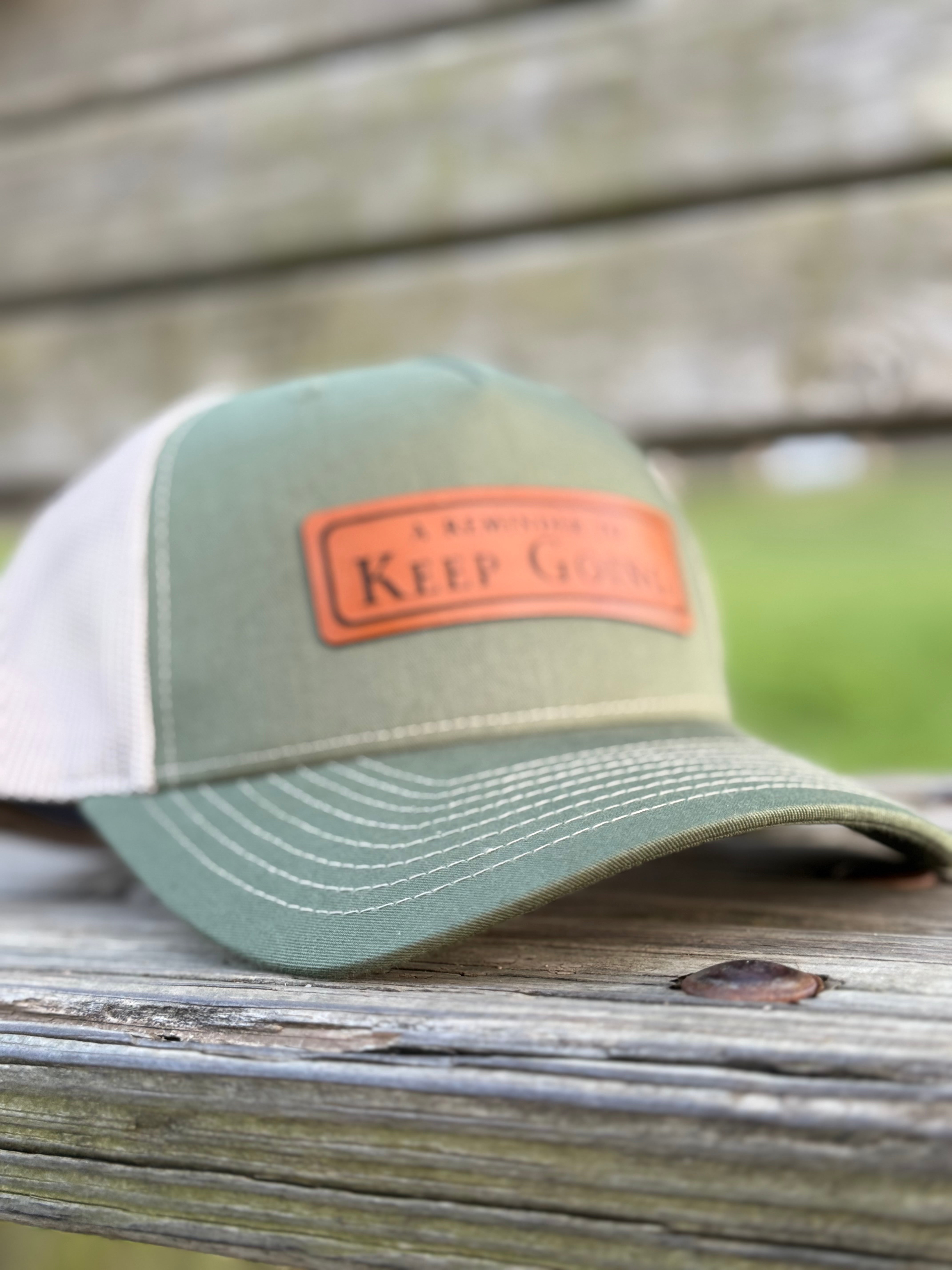 Green and white cap with a leather patch on a wooden surface