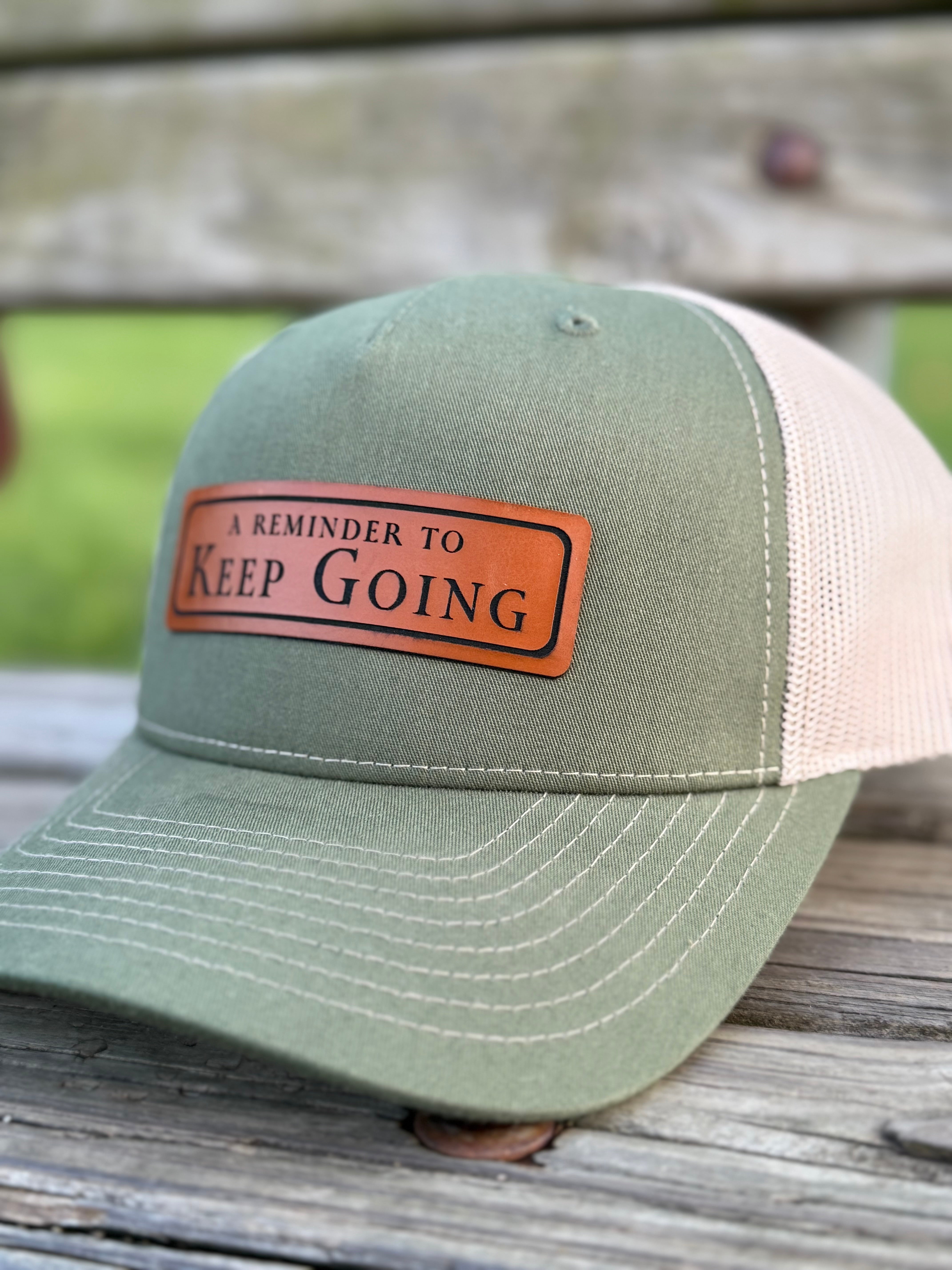 Green and beige cap with a leather patch on a wooden surface