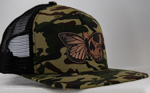 Camouflage cap with a butterfly and skull design on a white background