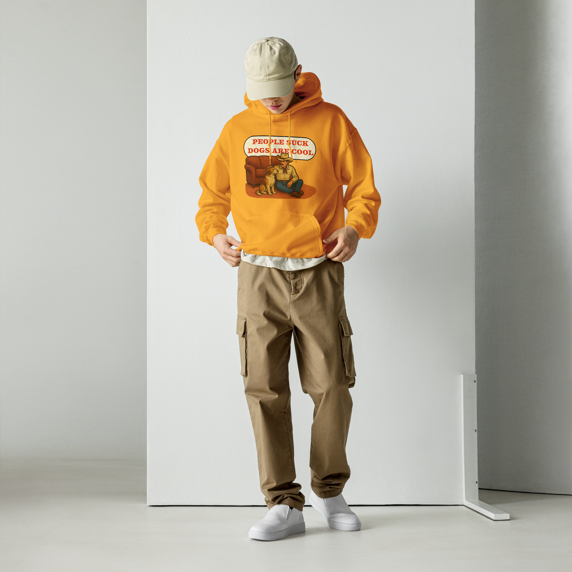 Person wearing an orange hoodie with a graphic design and brown cargo pants against a white background